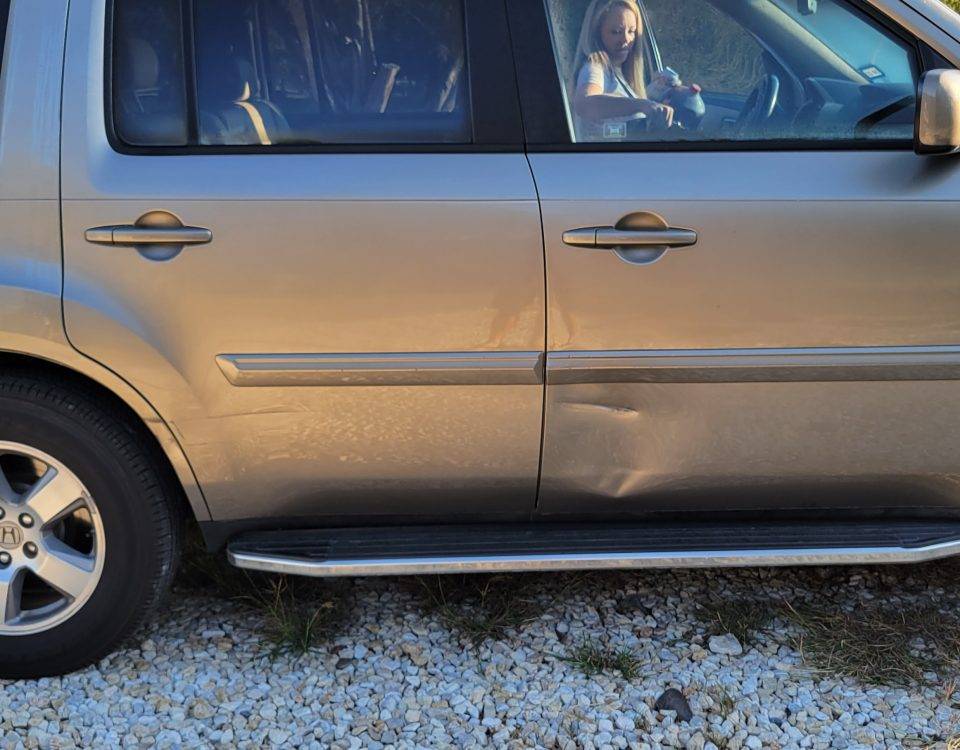 Repair or replace the dented door panel