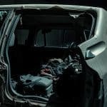 Damaged vehicle interior showing fender and rear compartment, illustrating repairs needed after a stolen car recovery.